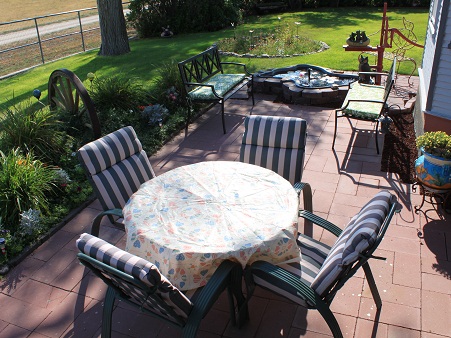 The South Lawn. Open air patio with a grill and wagon wheel flower garden.